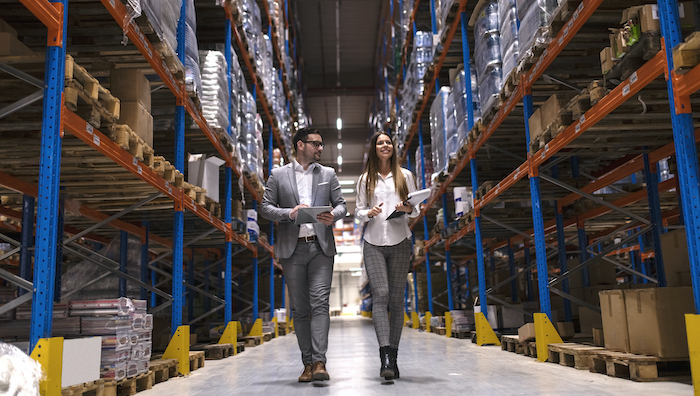 two business owners walking through their organized inventory